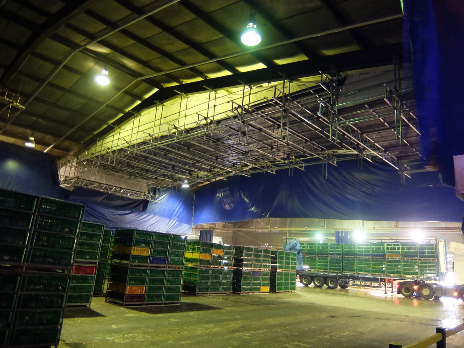 Scaffold deck erected at roof level inside a large industrial building